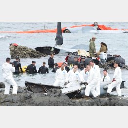 墜落したオスプレイ残骸のそばで笑顔で記念撮影する米兵（琉球新聞提供）