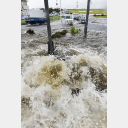 道路脇のマンホールからあふれる水＝2015年9月、栃木県小山市（Ｃ）共同通信社