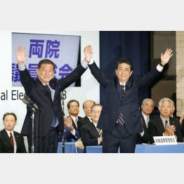 党総裁選を終え石破元幹事長（左）と手を取り合う（Ｃ）共同通信社