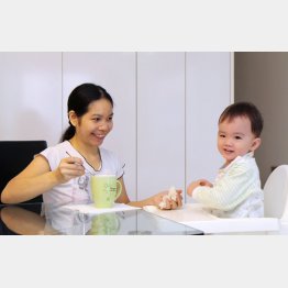 赤ちゃんに朝食を食べさせるフィリピン人家政婦（シンガポール）／（Ｃ）共同通信社