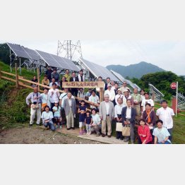 住民が力を合わせて設置した「まめってぇ鬼無里発電所」。関係者が集まって記念撮影（筆者著「信州はエネルギーシフトする」から）