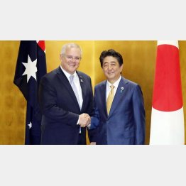 G20大阪サミットで握手するオーストラリアのモリソン首相（左）と安倍首相（Ｃ）共同通信社