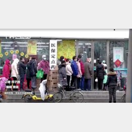 中国・武漢市で、マスクを着け処方箋薬局に列を作り並ぶ人たち（Ｃ）ロイター／中国通信社