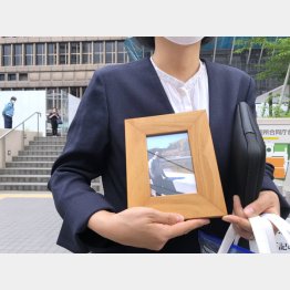 第1回口頭弁論を終え大阪地裁前で遺影を掲げる赤木雅子さん（撮影・筆者）