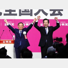 両手を上げる菅首相（左）と山口代表（27日、公明党の党大会で）／（Ｃ）共同通信社