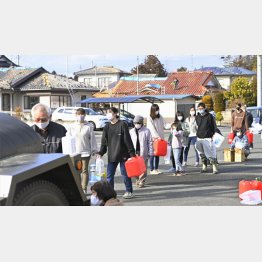 14日、断水で給水車に並ぶ人たち（震度6強の地震があった福島県新地町）／（Ｃ）共同通信社