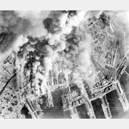 米第21爆撃軍団の戦略爆撃機B29の爆撃で黒煙を上げる神戸港の海軍基地＝1945年6月、米陸軍航空隊撮影（ACME）