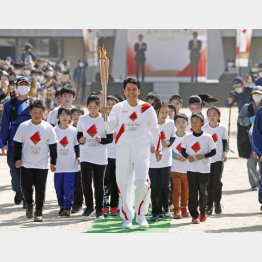 長野県飯田市をスタートする聖火ランナーの峰竜太さんと地元の子どもたち（Ｃ）共同通信社