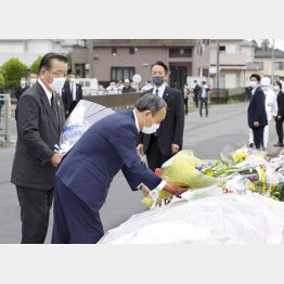 児童5人が死傷した事故現場の献花台に花を手向ける菅首相（手前）。左は千葉県八街市の北村新司市長（代表撮影）