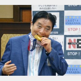 首に掛けられた後藤希友選手の金メダルをかじる河村たかし名古屋市長（Ｃ）共同通信社