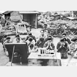 焼け跡で玉音放送をラジオで聞き、涙を流す戦災者たち＝1945年8月15日（Ｃ）共同通信社