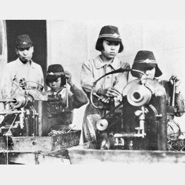 「女子挺身（ていしん）隊」の若い女性が勤労奉仕で工場などへ大量動員された。航空機製造の軍需工場へも駆り出され、戦闘帽をかぶって旋盤機械を操作する表情にも幼さが残る＝1944（昭和19）年6月8日（Ｃ）共同通信社
