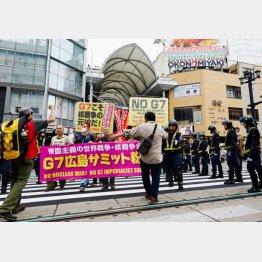 広島でのG7サミットに抗議するデモ参加者の人たちと警察官（Ｃ）ロイター