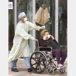 2003年、カナダでSARSが流行し273人が感染した（退院するSARS高齢患者を、彼女の車まで付き添う防護服の病院従業員）／（Ｃ）ロイター