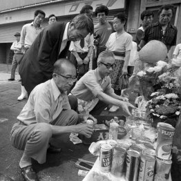 犯行現場の路上に設けられた祭壇に花やジュースなどを供える近所の人たち（Ｃ）共同通信社